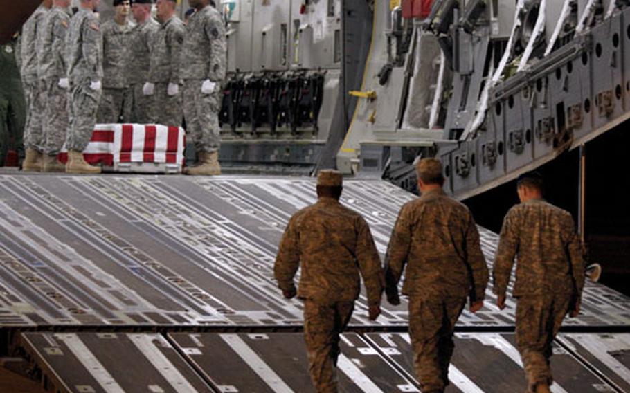 Army Brig. Gen. Walter Davis, Air Force Col. Robert Edmondson and Chaplain Maj. Klavers Noel, left to right, approach the C-17 at the start of the dignified transfer of Spc. Israel Candelaria Mejias’ body.