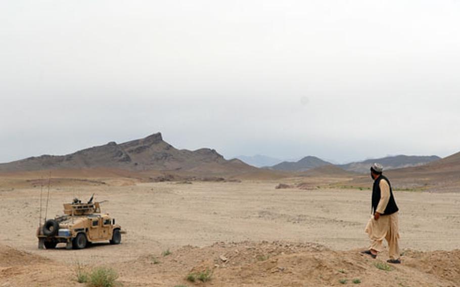 Walkhan, a National Police checkpoint commander, looks over the rugged terrain of southern Afghanistan’s Arghandab district on Saturday near Khaneh Gerdab. The lack of paved roads and the expansive area keep the American police mentoring team for the area busy.