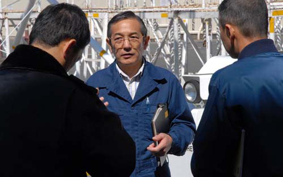 Toshio Murakami, a mechanic foreman with nearly 30 years on the job with the U.S. military, helps explain the workings of U.S. Navy aviation support equipment to members of the Japan Maritime Self-Defense Force Detachment 44 during a training course Wednesday at Naval Air Facility Misawa, Japan.