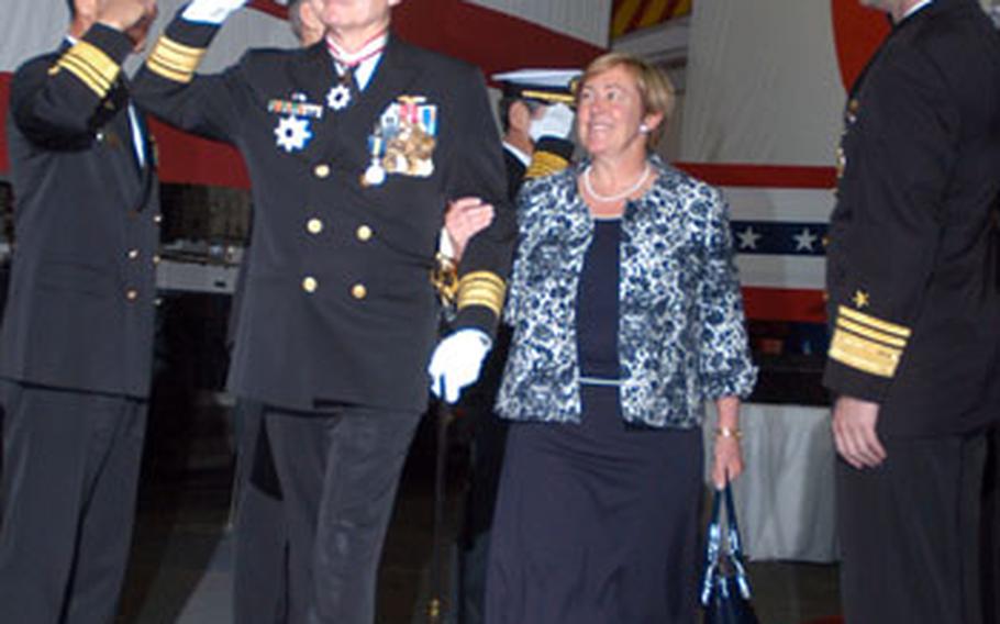 Rear Adm. James Kelly exits the stage with his wife, Amy, after the Commander, Naval Forces Japan change-of-command ceremony Thursday. Kelly, who has 36 years of naval service, will retire on June 30. Rear Adm. Richard Wren took over as the new Commander, Naval Forces Japan.