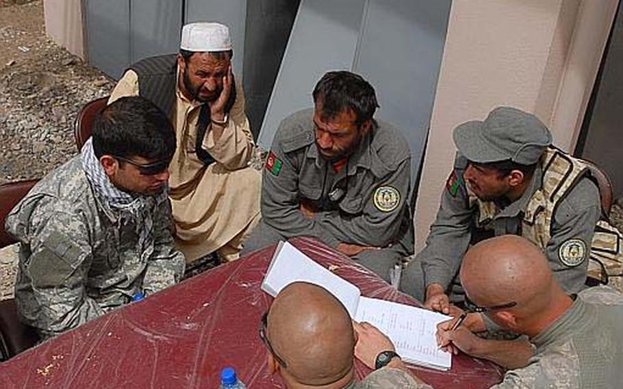 American soldiers talk with Afghan National Police in the Arghandab district Thursday about supplies they need to improve their checkpoints.