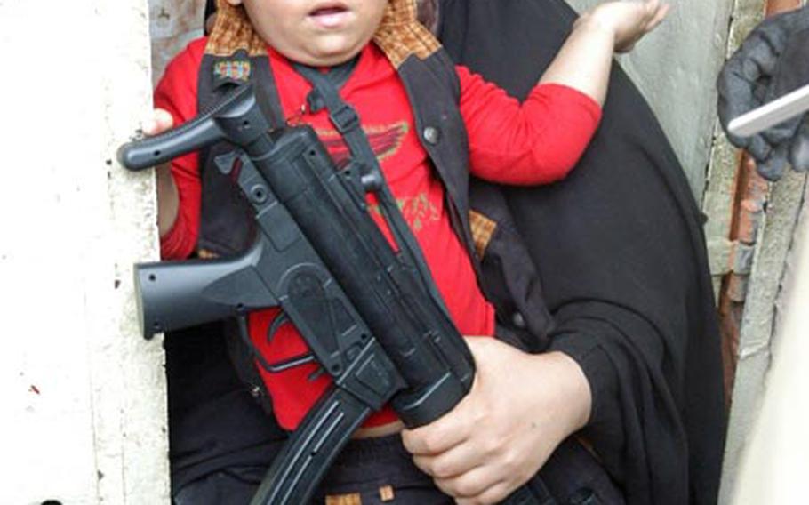A woman is scolded by U.S. paratroops last week after her son was seen with a realistic-looking toy gun in Baghdad&#39;s Fadhil neighborhood.