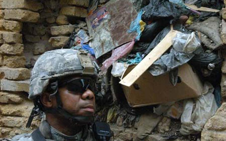 Sgt. Walter Jackson of Alpha Troop, 5th Squadron, 73rd U.S. Cavalry Regiment stands next to trash coming out of the windows last week in Baghdad&#39;s Fadhil neighborhood. Jackson and other paratroops stationed in the area were leading civil affairs soldiers and local politicians around to see which of the giant garbage piles should be cleaned up first.