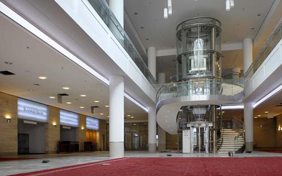 Newly installed red carpet leads to a glass encased elevator that serves the billeting lobby portion of Ramstein’s Kaiserslautern Military Community Center.