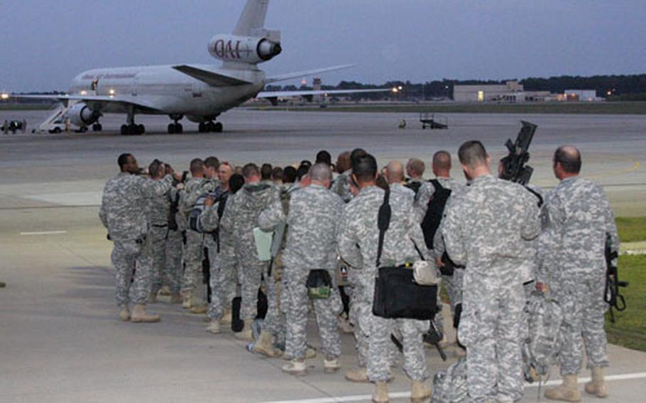 Soldiers line up to board the plane.