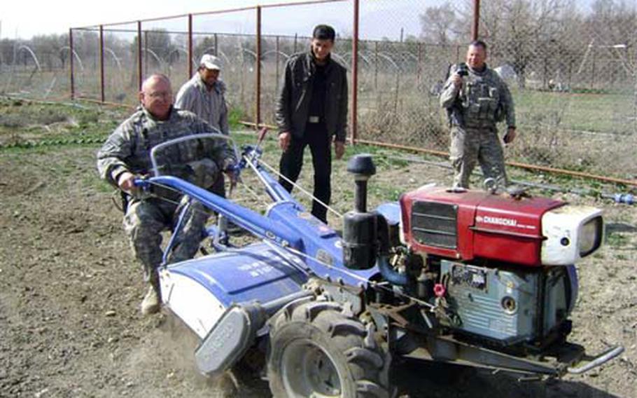Master Sgt. John Herron uses a walk-behind tractor to prepare a test plot March 19 at Kabul University. An agricultural development team is working to boost Afghanistan’s agriculture.