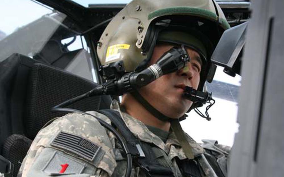 U.S. Army Maj. Lee Fennema peers into the eyepiece of the computer-integrated helmet, which displays certain aircraft data.