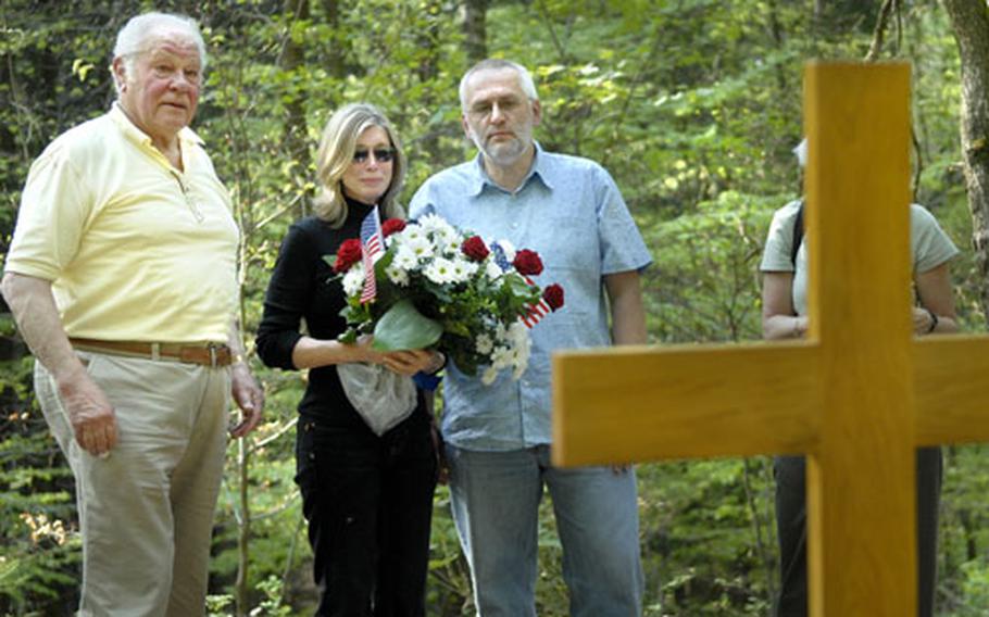 Richard Graff, Jan Loftis and Uwe Binkel, left to right, in front of a cross placed at the crash site. Loftis&#39; uncle, Anthony Burroughs, was one of three crew members who died in the crash.