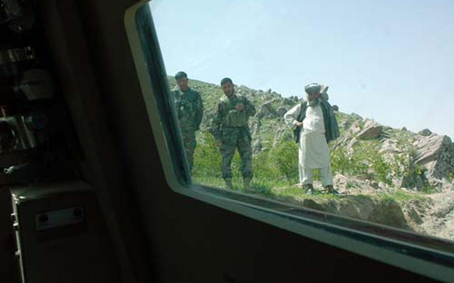 Afghan soldiers and a local villager watch U.S. soldiers try to pull out an MRAP that threatened to tip over when it tried to cross a river Saturday in the Tag Ab valley of eastern Afghanistan. Villagers warned the Americans that the water was chest high before they tried to cross.