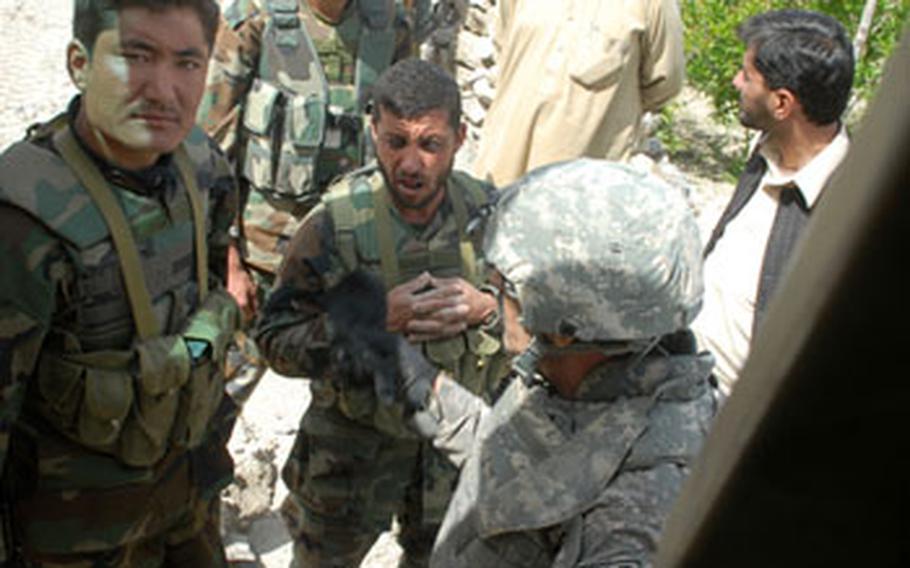 An interpreter (front right) translates for Afghan soldiers upset about the decision to take a risky route to inspect a road project and meet with local leaders Saturday in Afghanistan’s Tag Ab valley. The soldiers eventually decided not to go on the mission without the permission of their commander.