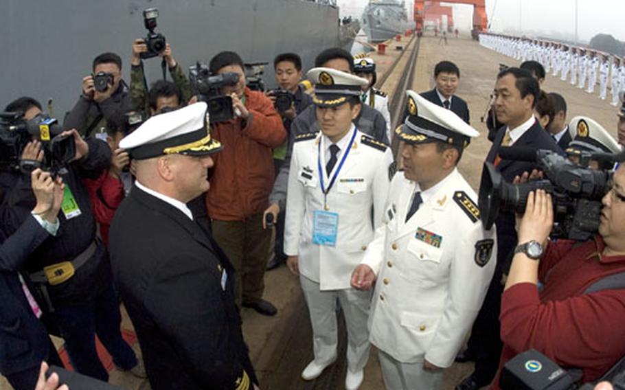 USS Fitzgerald commanding officer, Cmdr. Richard Dromerhauser, speaks with officers of the People&#39;s Liberation Army navy following Fitzgerald&#39;s arrival in the port city of Qingdao, China. Fitzgerald is in China to take part in the International Fleet Review, a 60th anniversary celebration of the founding of China&#39;s navy.