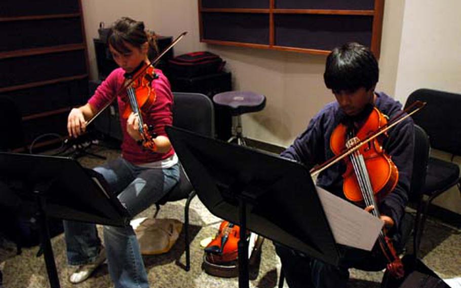 Nigal Shah (right), a freshman at Kinnick High School at Yokosuka Naval Base, Japan, plays his viola alongside a fellow member of the Far East Honor Music Festival string ensemble during practice Tuesday afternoon.