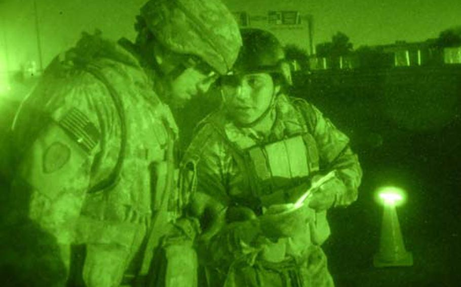 Sgt. Guadalupe Ramos (left) of Troop C, 5th Squadron, 4th Cavalry Regiment, chats with an Iraqi soldier during a night mission in Khadra to move blast barriers.