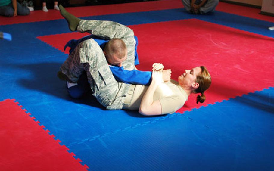 Capt. Jodi Kelsey prepares to put one of her instructors into an arm bar during a sexual assault prevention class at Yokota Air Base, Japan. Titled "My Strength is for Defending," the class provided the approximately 14 female students a chance to learn about how to defend themselves using basic jujitsu techniques.