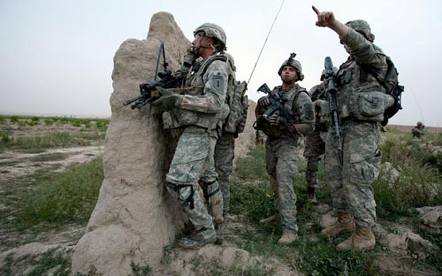 A soldier with Company A, 2nd Battalion, 2nd Infantry Regiment points out the location of a possible gunman after Taliban fighters attacked their patrol near Mira Hor.
