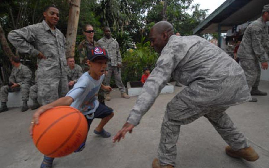 Eleven-year-old Yaswn, of the Duyan Ni Maria Children’s Home in Angeles City, Philippines, takes Air Force Staff Sgt. Derek Smith to the hoop Friday. Smith, and other members of the 56th Fighter Wing, from Luke Air Force Base, Ariz., visited the home as part of a community relations project during the annual Balikatan training exercise. The airmen presented boxes of toys – including plenty of sports equipment – and about $250 during the visit.