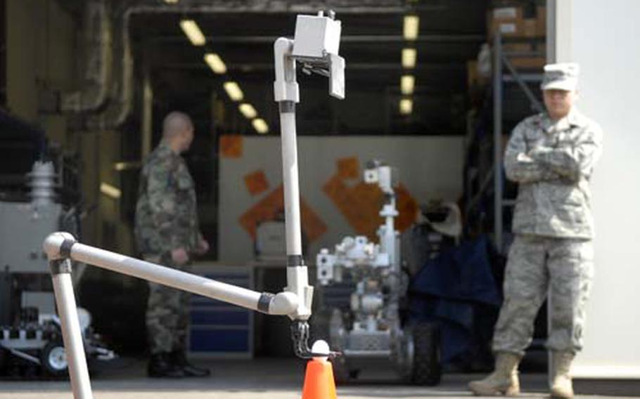 Staff Sgt. Kevin Cummings, a bomb disposal craftsman, watches as a robot transports an egg to a traffic cone.