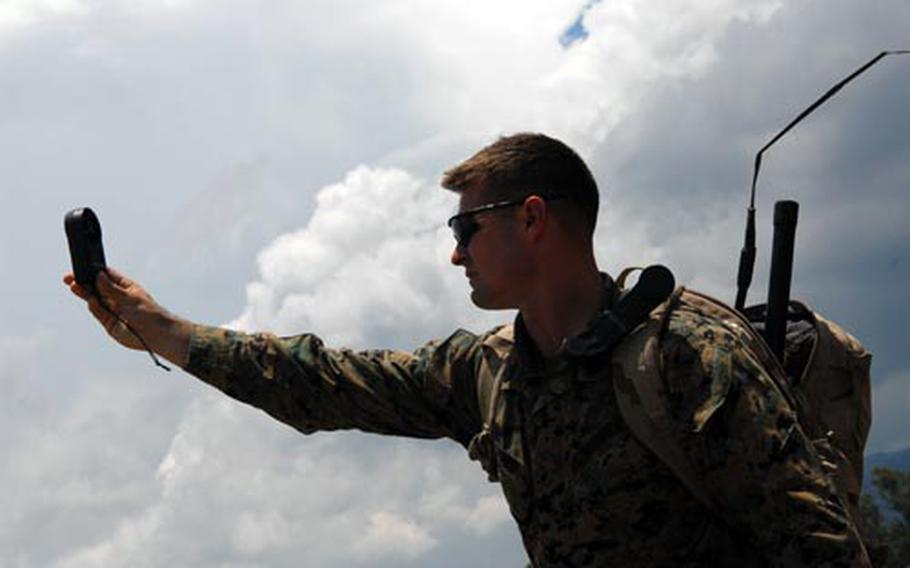 Gunnery Sgt. Blaine Jones, a jumpmaster with Okinawa’s 3rd Reconnaissance Battalion, checks the wind strength on a drop zone Friday in the Philippines. Jones and his team were providing parachute training to Balikatan 2009 participants.