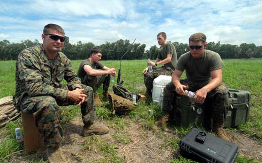 From left: Gunnery Sgt. Blaine Jones, Cpl. Glenn Trahan, Cpl. Jordan Gowland and Lance Cpl. Josh Tebben -– with Okinawa’s 3rd Reconnaissance Battalion -- wait Friday on a drop zone that was once part of the U.S. Air Force’s Clark Air Base in the Philippines. The team was providing parachute training for members of the annual Balikatan training exercise.