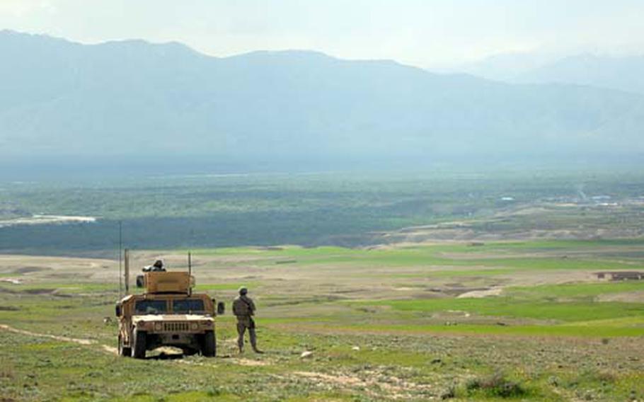 Soldiers pull security while scouting out the site of a planned road in rural Kapisa province, Afghanistan. Leaders hope roads both spur development and educate officials on key government processes.