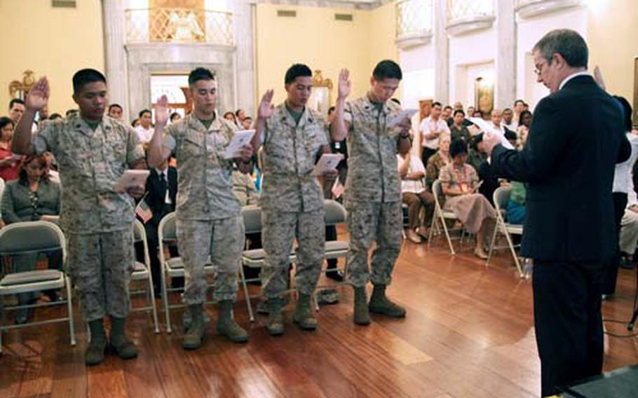 From left, Seaman Mario Vinoya, Lance Cpl. Jose Rodriguez Peralta, Seaman Renny Vitug and Seaman Jin Lin recite the oath of citizenship during a naturalization ceremony Monday at the U.S. Embassy in the Philippines.