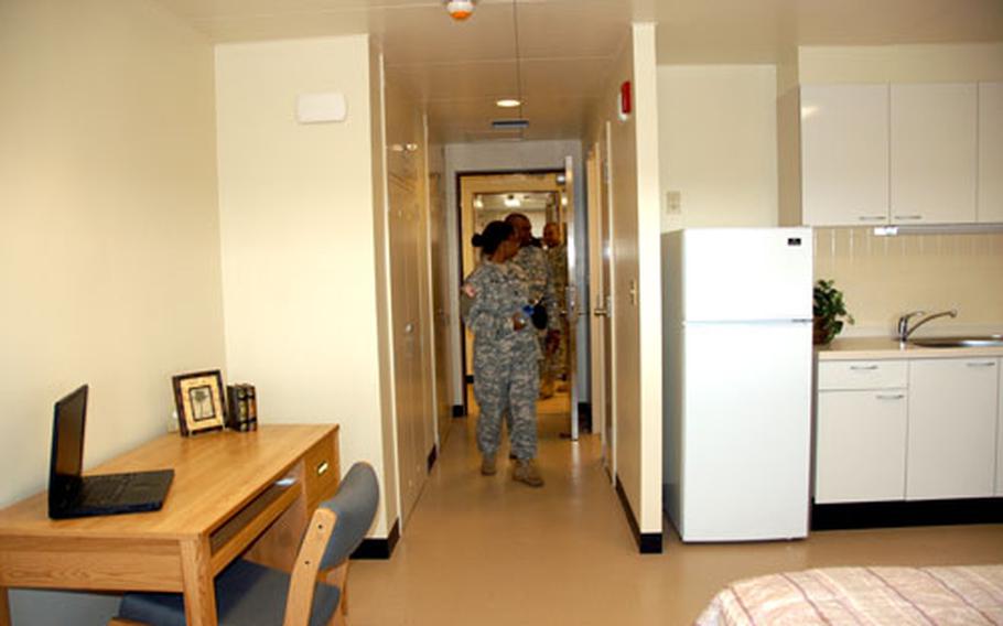 Soldiers check out the newly remodeled barracks rooms Wednesday following the dedication ceremony. Each room is equipped with a fridge, microwave, private bathroom, computer desk and full bed.