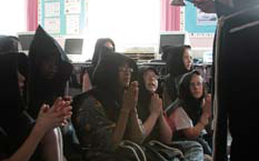 Jan Munt, an education outreach coordinator at Ely Cathedral, teaches Lakenheath Middle School students about monastic traditions in her “A Day in the Life” program on medieval monks at the school’s U.K. Day last week. Students took a vow of silence for the duration of the lesson.