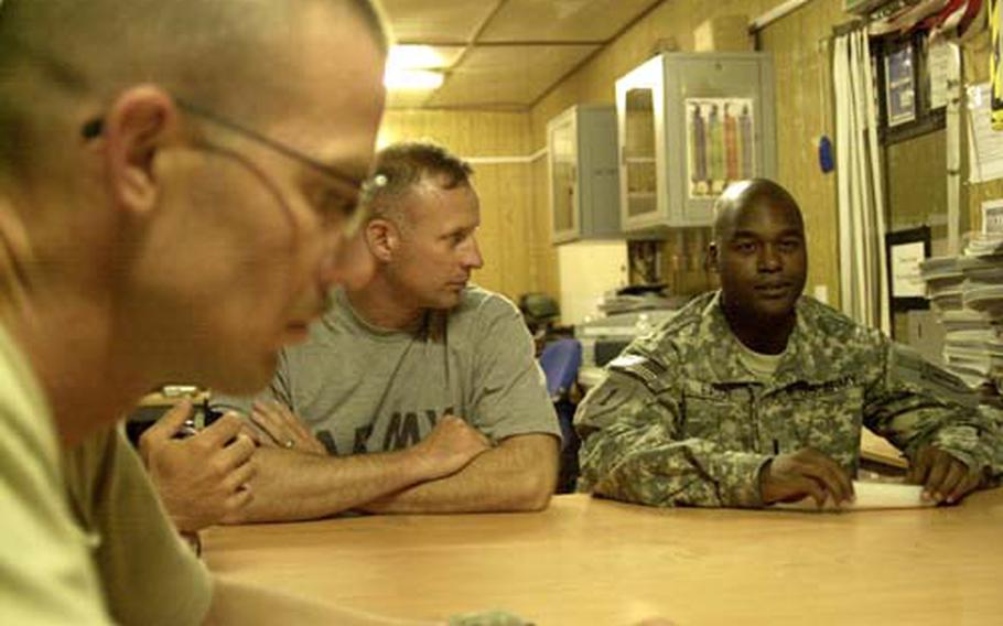 Sgt. 1st Class David Rieckmann, left, and Sgt. 1st Class Damon Smith listen as 1st Lt. Jeremy Eaddy talks about the bomb that hit Maj. Steven Hutchinson&#39;s truck on May 10. Eaddy was the driver.