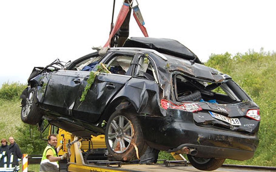 Workers lift an Audi station wagon onto a tow truck following a fatal crash on Autobahn 63 near Kaiserslautern. Three U.S. soldiers assigned to Baumholder, Germany, were killed in the Sunday morning crash.