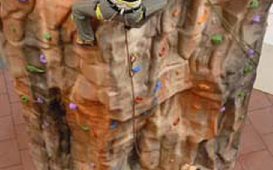 Arielle Zieja scales an inverted tower as Jerry Leake practices belaying.