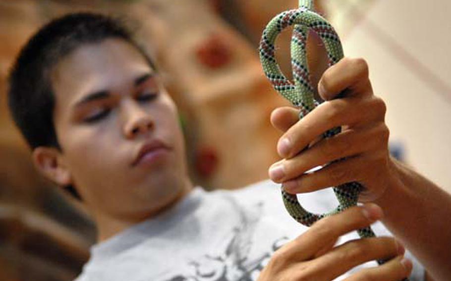 Jonathon Harden ties a figure eight knot to his harness.