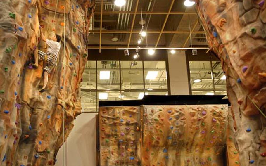 Jonathon Harden, left, ascends one of Outdoor Recreation&#39;s climbing walls.