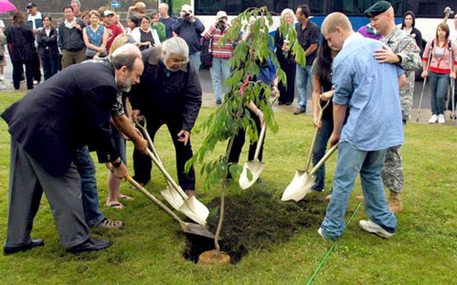 Alumni, current students, faculty and base officials take part in a tree-planting ceremony at Zama American High School. The school celebrated the 50th anniversary of their first graduating class this weekend.