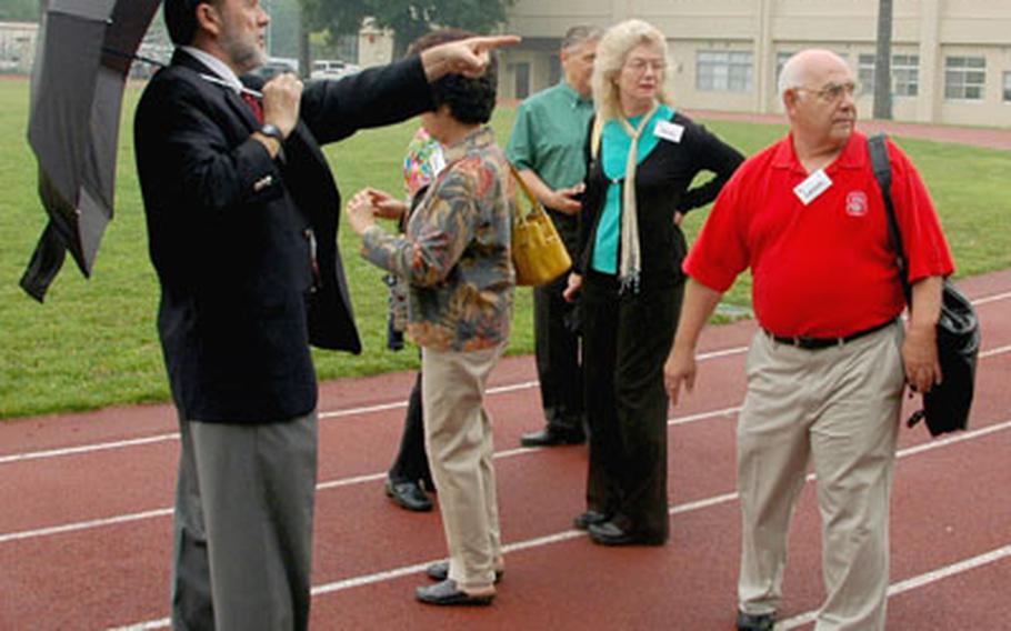 Zama American High School Principal Jerry Ashby, left, points out landmarks to visiting alumni during a tour of the school Friday morning.