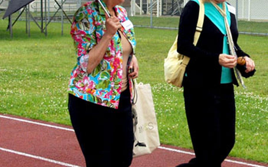 Walking along the school track, former majorettes Jeanne Fredericks, left, representing the class of 1965, and Terry Englehart, class of 1966, reminisce about their days at Zama American High School.