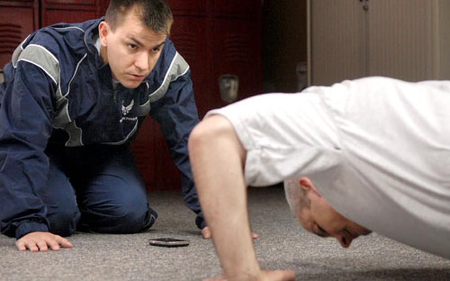 First Lt. Casey Ralston counts out push-ups for Lt. Col. James Sheridan during an Air Force physical fitness test in May at Ramstein Air Base, Germany. Ralston is the Unit Fitness Program Manager for the 435th Mission Support Squadron.