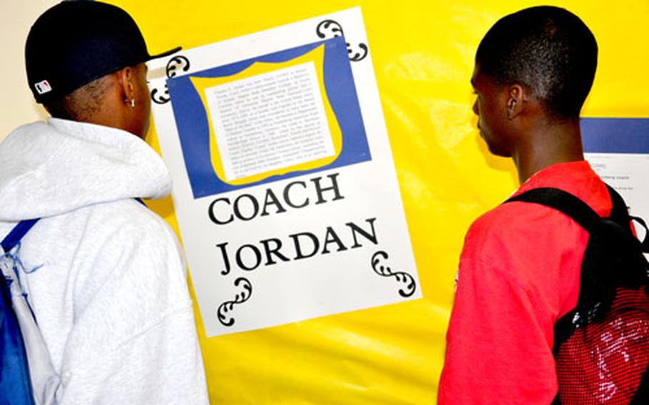 Quadel Webb, left, and Will Porter, both 10th grade basketball players and students at the Bamberg American High School, read a tribute to Charles E. "Chuck" Jordan on Wednesday..