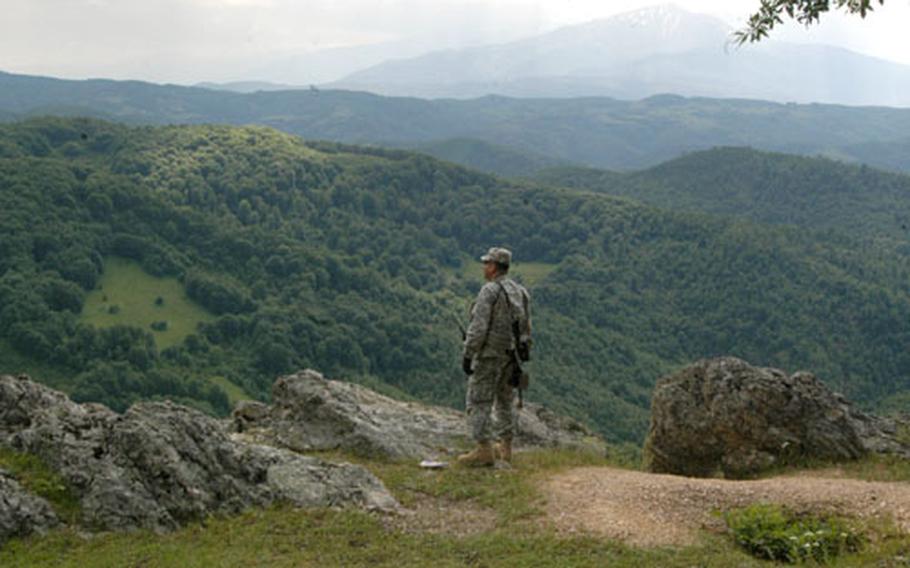 Staff Sgt. Luis Rivera looks toward the border of Macedonia from a viewpoint in the mountains of Kosovo during a recent patrol. Rivera and his troops meet routinely with Kosovo Border Police and their counterparts across the border to monitor events between the two countries.