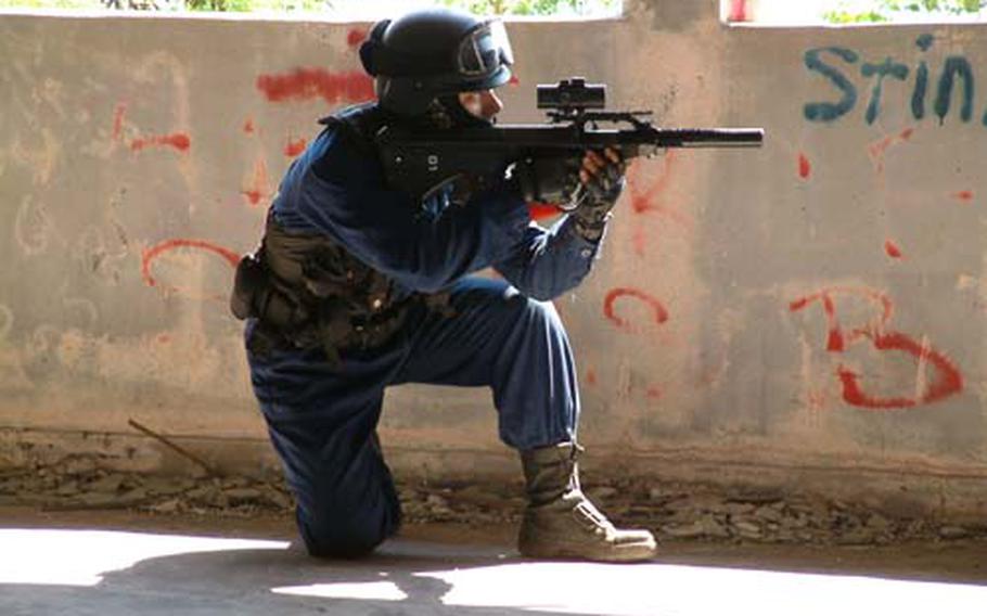 (Oct. 2006) A Japanese military gamer takes aim at an opponent inside the ruins of the Royal Hotel, also know as the Hotel Takahara, in Nakagusuku, Okinawa. The "haunted castle" has been placed off limits to all Marine personnel.