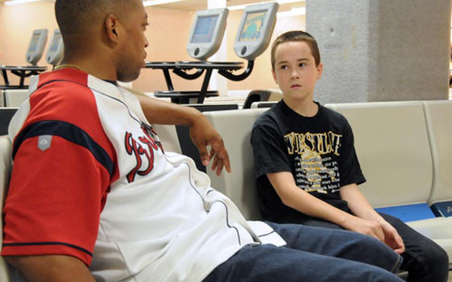 Air Force Master Sgt. Alando Respress, Air Force Smart Operations for the 21st Century process manager for the 18th Wing on Kadena Air Base, Okinawa, talks with Price Berill between games at the Emery Lanes bowling alley on base. The two have been teamed up for about six months, and get together twice a week.