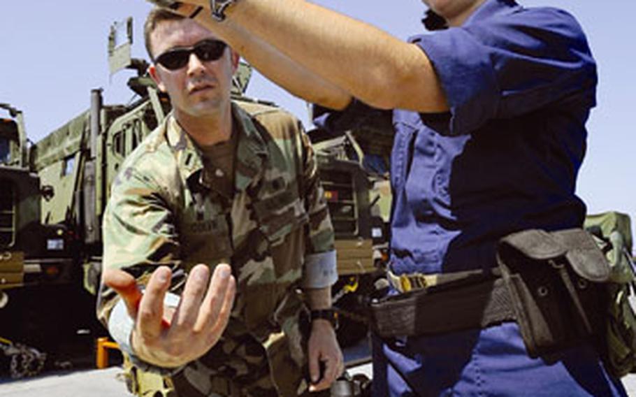 Lt. j.g. Frankie Colvin, left, prepares to catch Midshipman 2nd Class Sarah Van Cott’s magazine while reviewing small-arms fundamentals with the University of Michigan Navy ROTC student aboard the amphibious dock landing ship USS Fort McHenry in the Mediterranean Sea. Under new regulations, Navy ROTC students will be required to give five years of active-duty service upon commission.