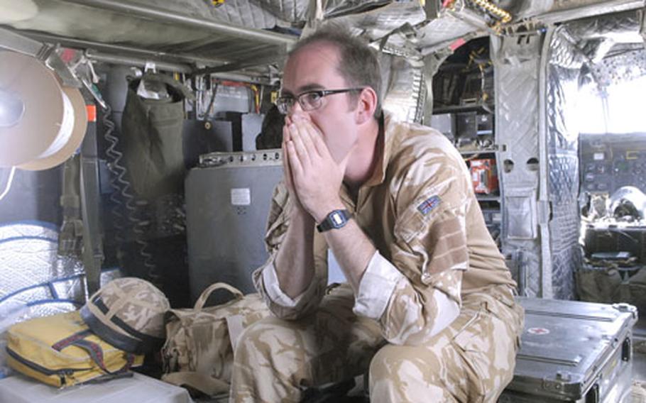 British Army Maj. Andy Haldane, 33, a member of the Medical Emergency Response Team, prepares himself mentally on the CH-47 Chinook helicopter after a call came through for a possible mission. The MERT can be ready in under 9 minutes from the time they get the call until take-off to pick up wounded soldiers or civilians.