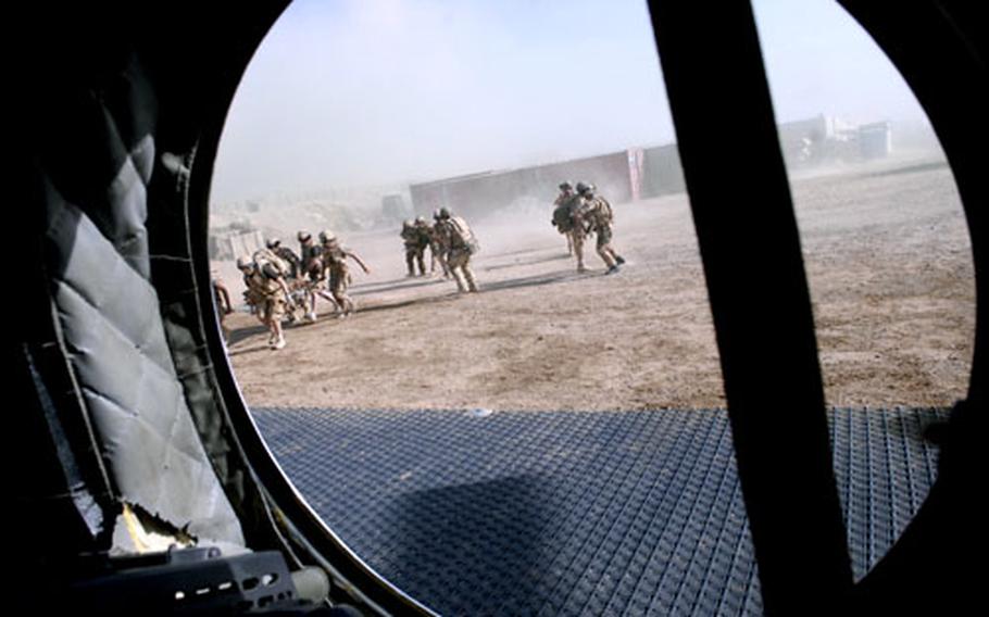 Members of the British military&#39;s Medical Emergency Response Team run toward their Chinook helicopter with a patient who was critically wounded by a makeshift bomb on the battlefield. On the helicopter, the MERT team are equipped to stanch bleeding, and give the patient fluids and blood transfusions.