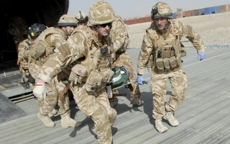 Members of the British military&#39;s Medical Emergency Response Team carry the critically wounded soldier from the CH-47 Chinook helicopter to an ambulance waiting on the ground near the hospital at Camp Bastion in Helmand Province.