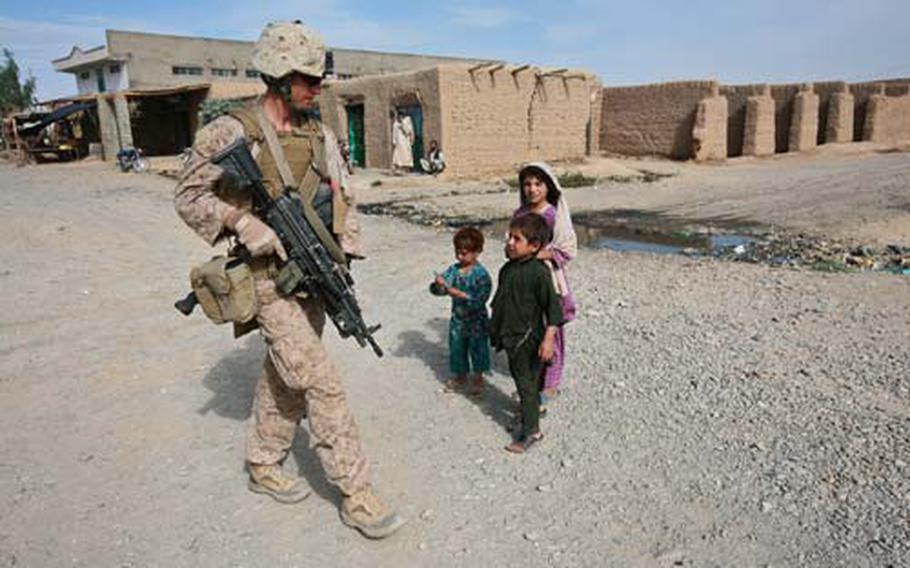 Children in the town of Delaram in southern Afghanistan&#39;s Nimruz province approach a member of Company I, 3rd Battalion, 4th Marine Regiment on patrol. Children frequently come out to greet the troops and ask for small gifrs, especially writing pens.