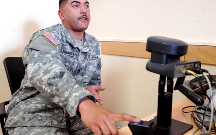 Staff Sgt. Amilcar Fernandes, of the 596th Maintenance Company in Darmstadt, Germany, has his fingerprint scanned to renew his identification card. (2006 file photo)