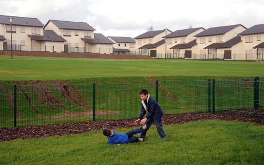 Austin, left, and Alex Loague play on the lawn behind their new house on Ramstein Air Base. In the background are more new townhouses that are being readied for occupancy.