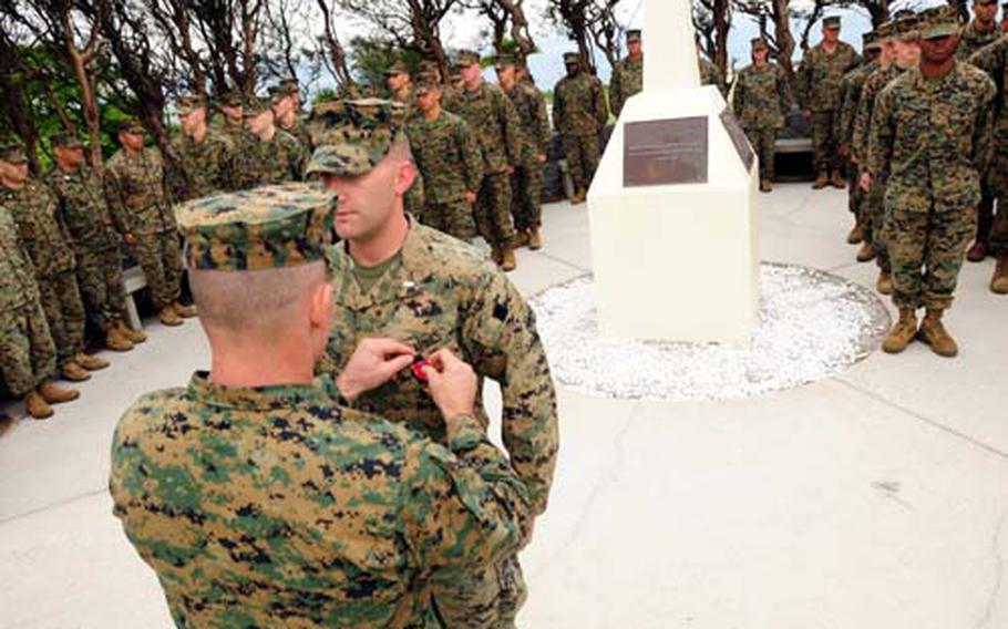 Marine 1st Lt. Colin P. Boynton receives the Bronze Star Medal with "V" for valor Friday at Camp Coutney, Okinawa, from Lt. Col. Ted Adams.