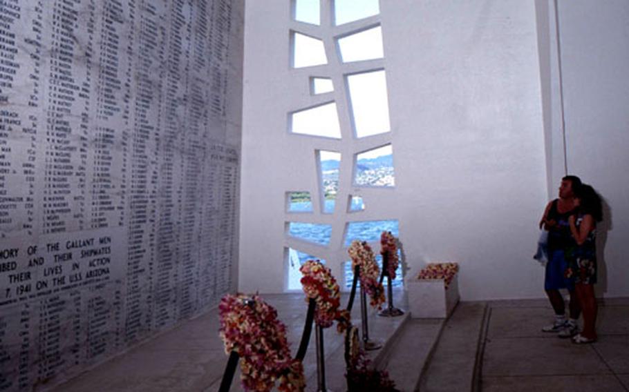 Visitors to the USS Arizona Memorial look at the wall listing the names of those killed in the December 7, 1941, attack.