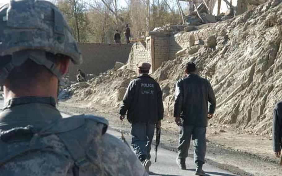 File -- Afghan police go on patrol with U.S. soldiers in 2009 in Wardak province, Afghanistan. Policemen often work without uniforms or the same equipment.